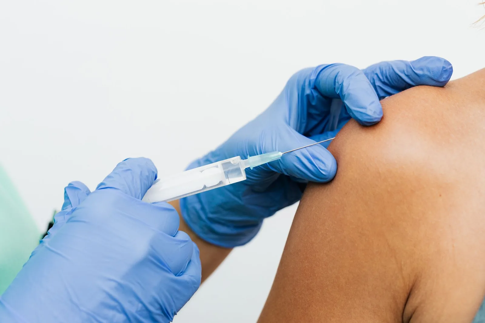Profissional de saúde aplicando uma injeção no braço de um paciente