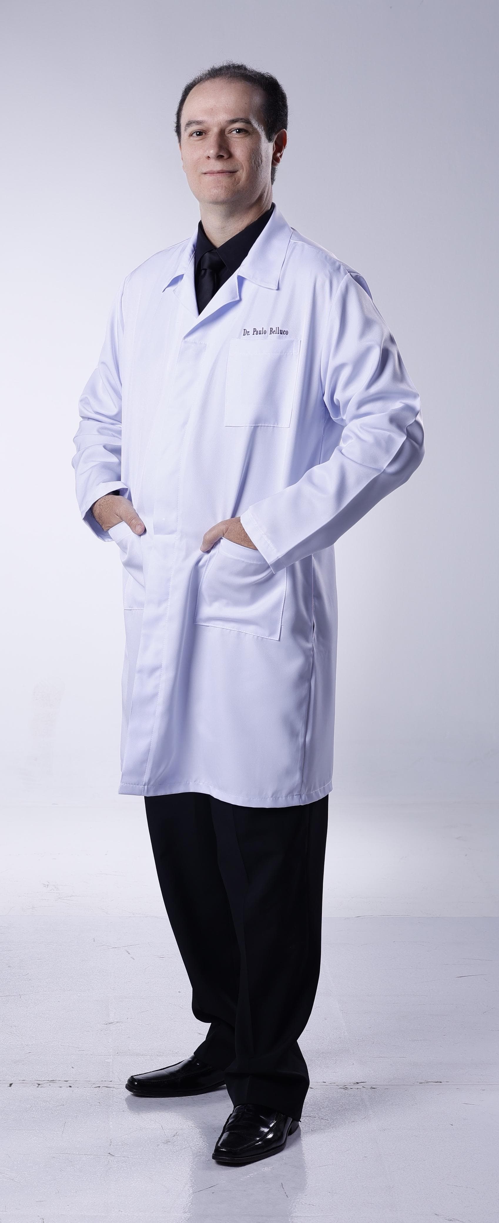 Dr. Paulo Belluco de jaleco branco, foto profissional de corpo inteiro